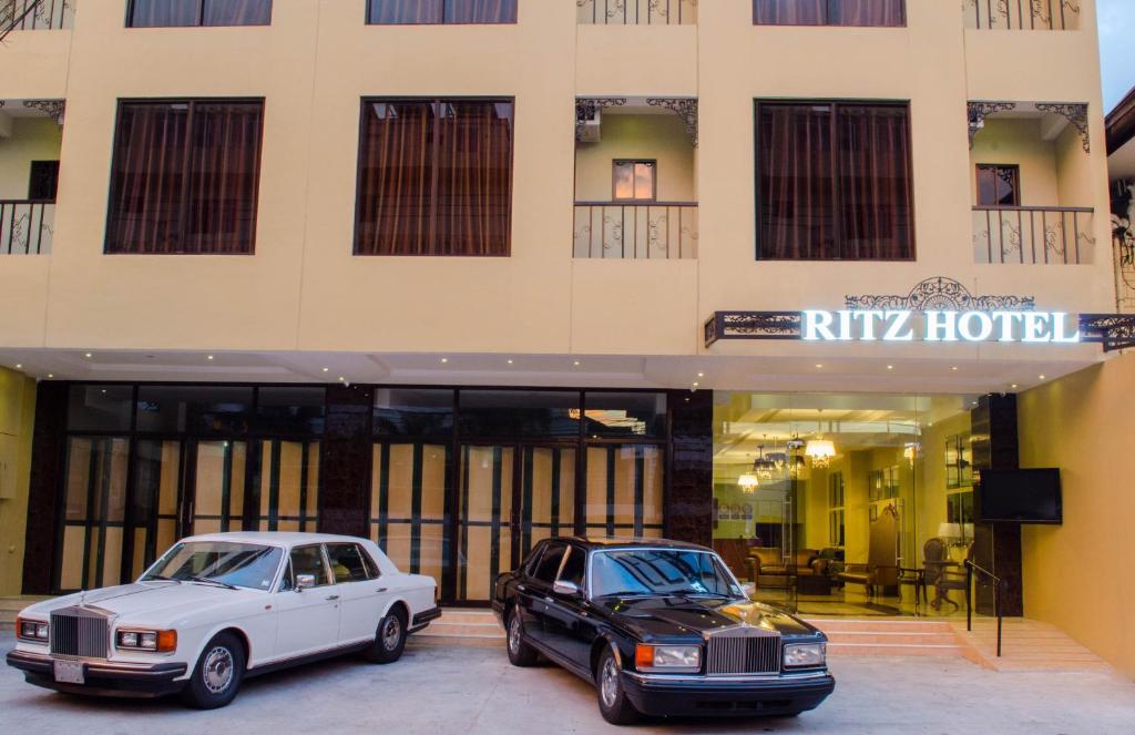 dos coches estacionados frente a un hotel en Ritz Hotel Angeles en Ángeles