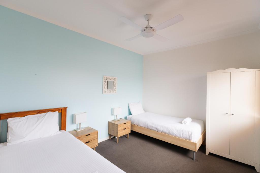 a bedroom with two beds and a cabinet at Six River - LJHooker Yamba in Yamba
