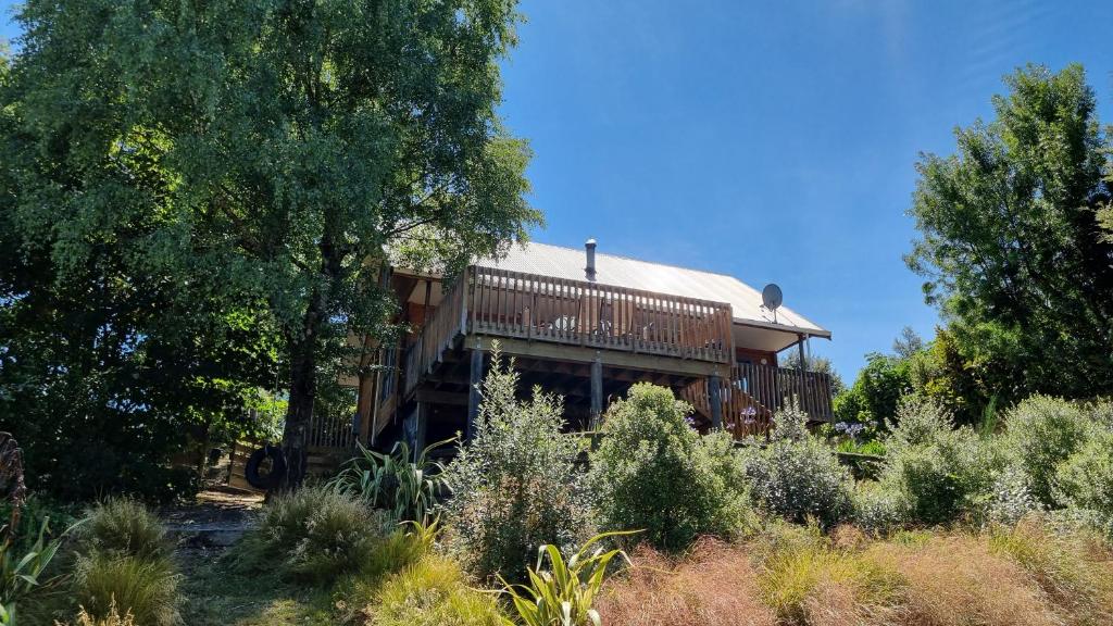 a house on a hill with trees and bushes at 19 Torquay Terrace in Hanmer Springs