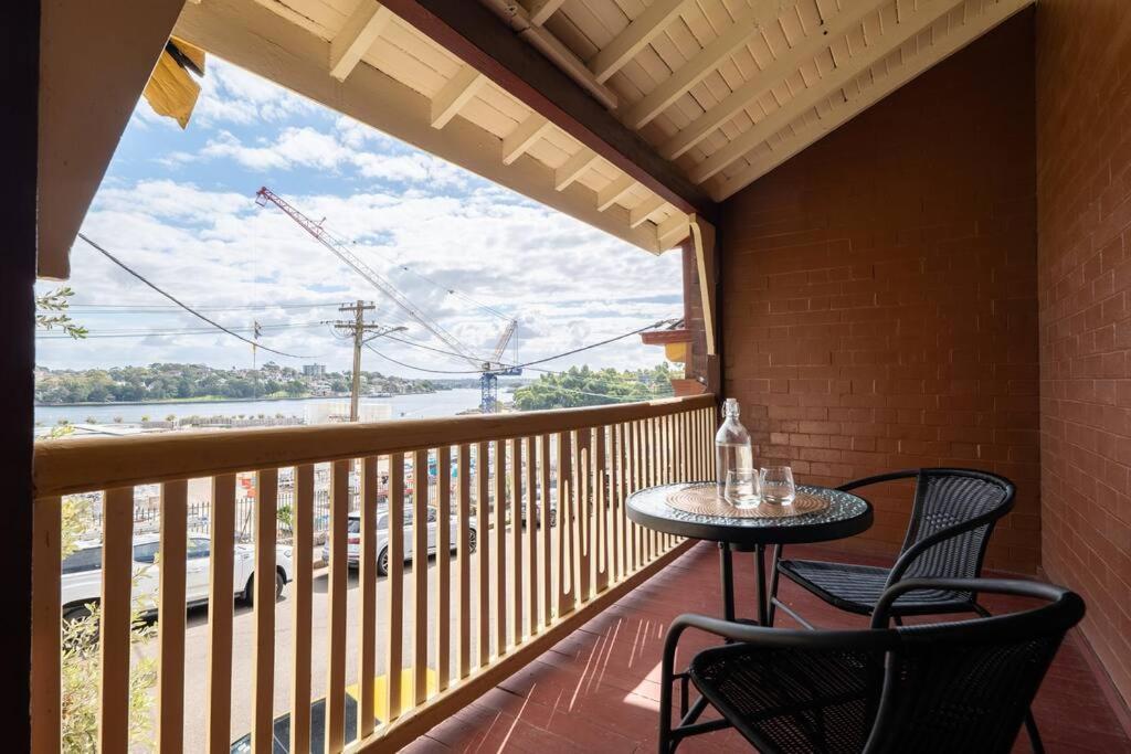a balcony with a table and chairs and a window at Waterfront - KING Bed Suite @ Rocks Sydney #10A in Sydney