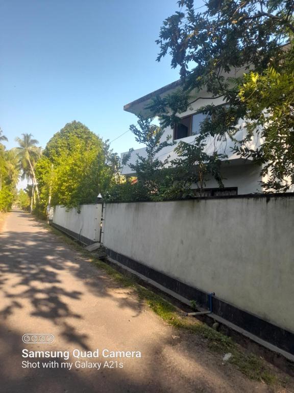 a fence next to a road with a house at Eura Villa in Bentota