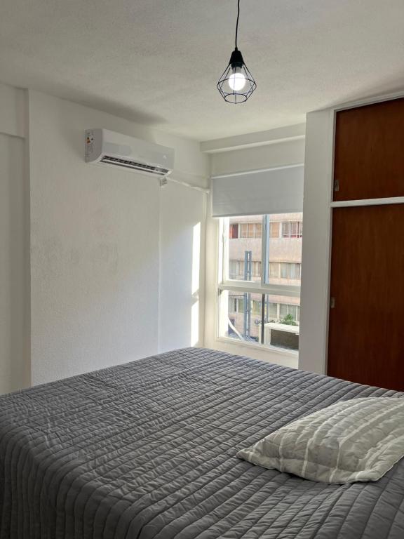 um quarto com uma cama e uma janela em Departamento Pleno Centro de Córdoba Capital em Córdoba