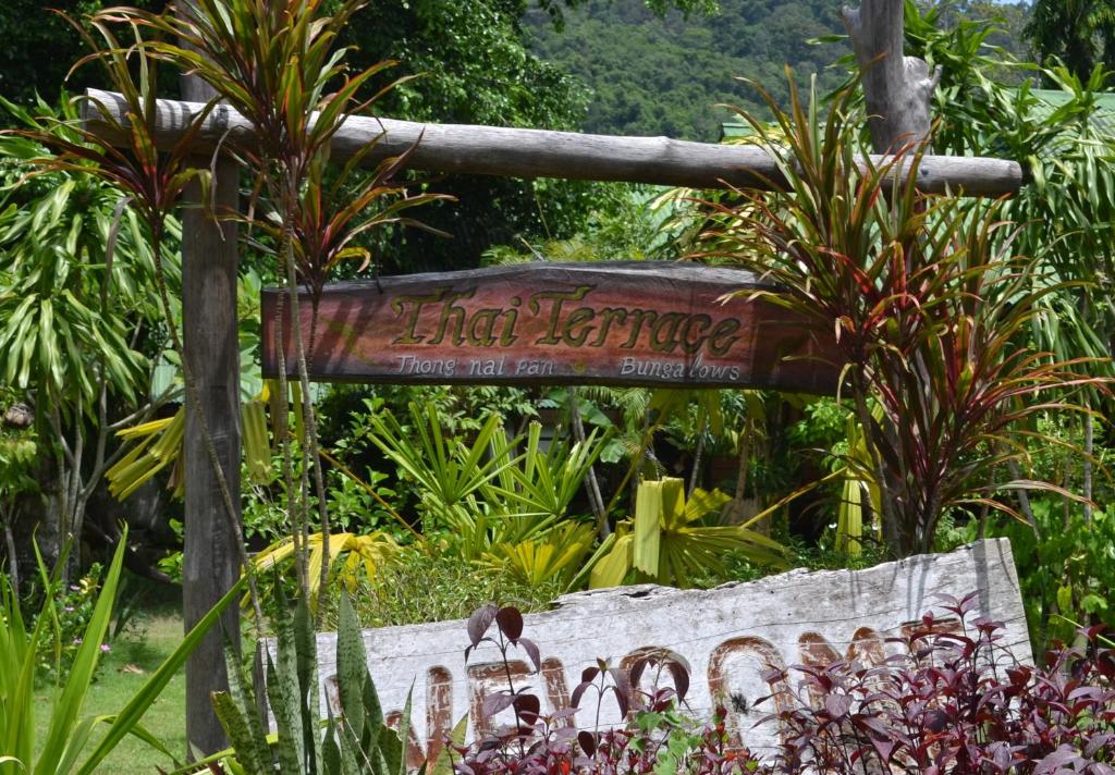 a sign in the middle of a garden with plants at Thai Terrace Bungalow in Thong Nai Pan Yai