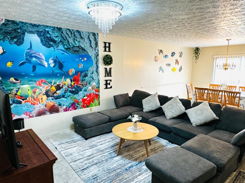 een woonkamer met een bank en een vismuurschildering bij Ocean Palace -12 Guests- close to I-75-Amazing Location!! in Maud