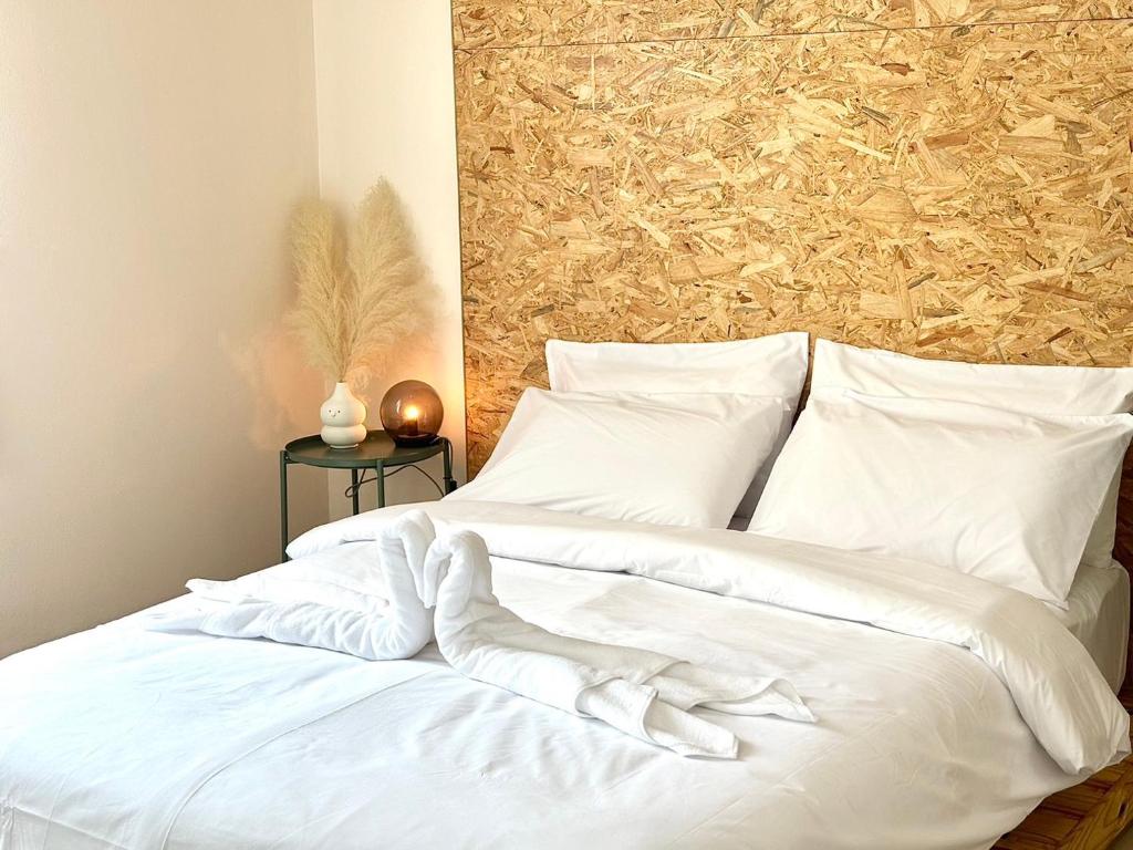 un letto bianco con lenzuola e cuscini bianchi di Willow Pillow Guest House & Poshtel a Chumphon