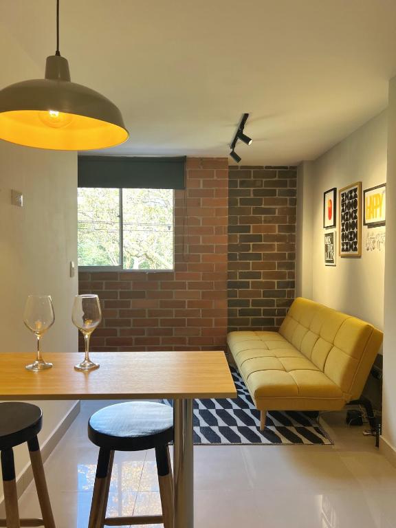 a living room with a yellow couch and a table at LOFT SOHO ICÓNICO CON BALCÓN in Sabaneta