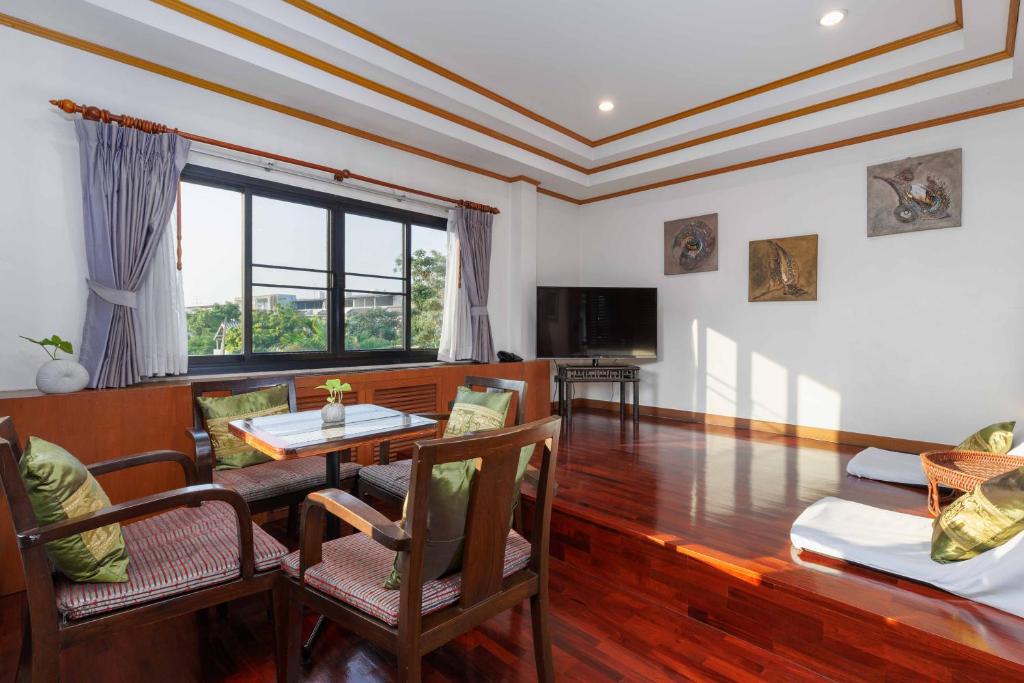 A spacious sitting room offers dining seating, a television and a broad window.