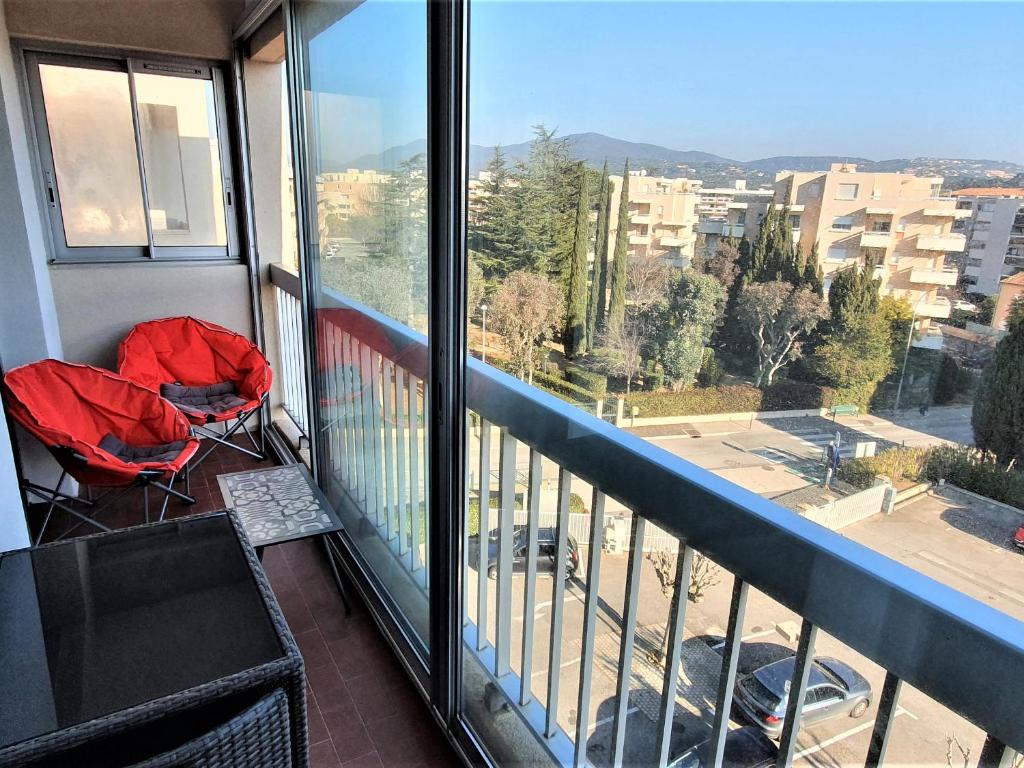 einen Balkon mit 2 Stühlen und Stadtblick in der Unterkunft Appartement Sainte-Maxime, 1 pièce, 2 personnes - FR-1-780-37 in Sainte-Maxime