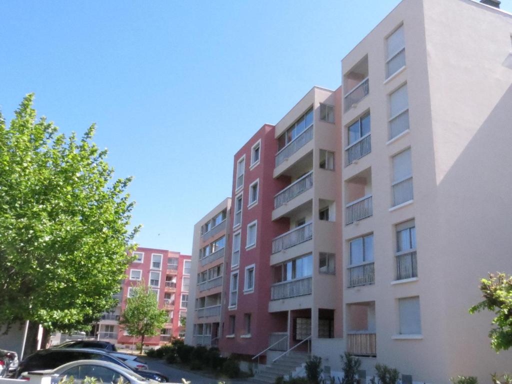 un immeuble d'appartements dans une ville avec des voitures garées à l'extérieur dans l'établissement Studio Centre Sainte-Maxime avec Parking – 2 Pers, Proche Mer, Loggia Équipée - FR-1-780-37, à Sainte-Maxime