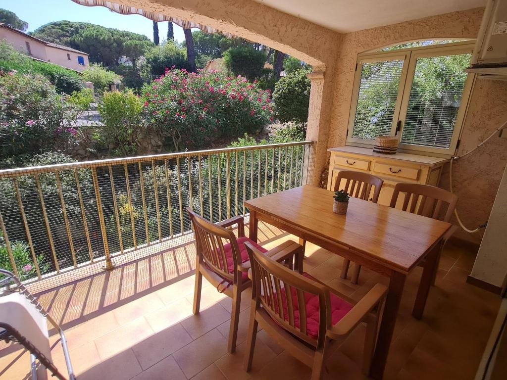 une terrasse couverte avec une table et des chaises en bois sur un balcon dans l'établissement Sublime 2 Pièces avec Clim, Terrasse, Piscine et Parking Privé, Proche Plages et Commerces à Sainte-Maxime - FR-1-780-20, à Sainte-Maxime