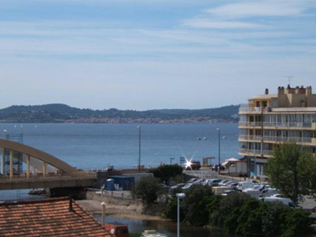 - une vue sur un port avec un bâtiment et un pont dans l'établissement Studio avec piscine, climatisation et parking à 100 m du centre et plage - Sainte-Maxime - FR-1-780-49, à Sainte-Maxime