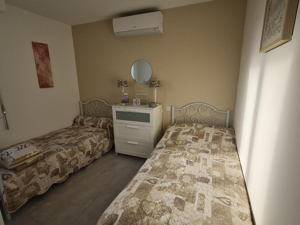 une chambre avec deux lits, une commode et un miroir dans l'établissement Bel Appartement 3 Pièces avec Terrasse et Climatisation à Sainte-Maxime - FR-1-780-39, à Sainte-Maxime