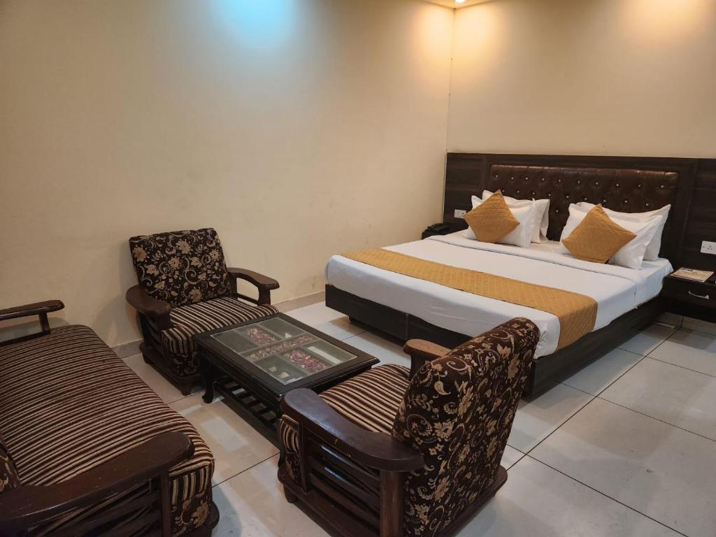 a hotel room with a bed and a chair at Hotel New City Lite in New Delhi