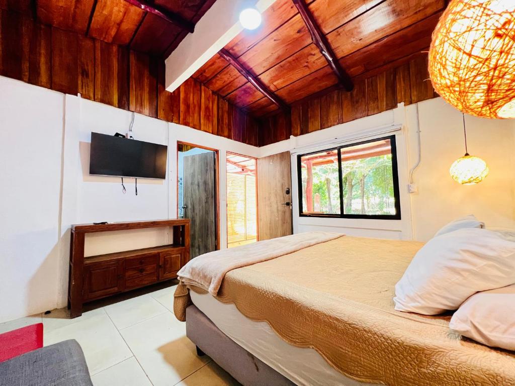 a bedroom with a bed and a flat screen tv at Perro Loco Villas in Paraíso