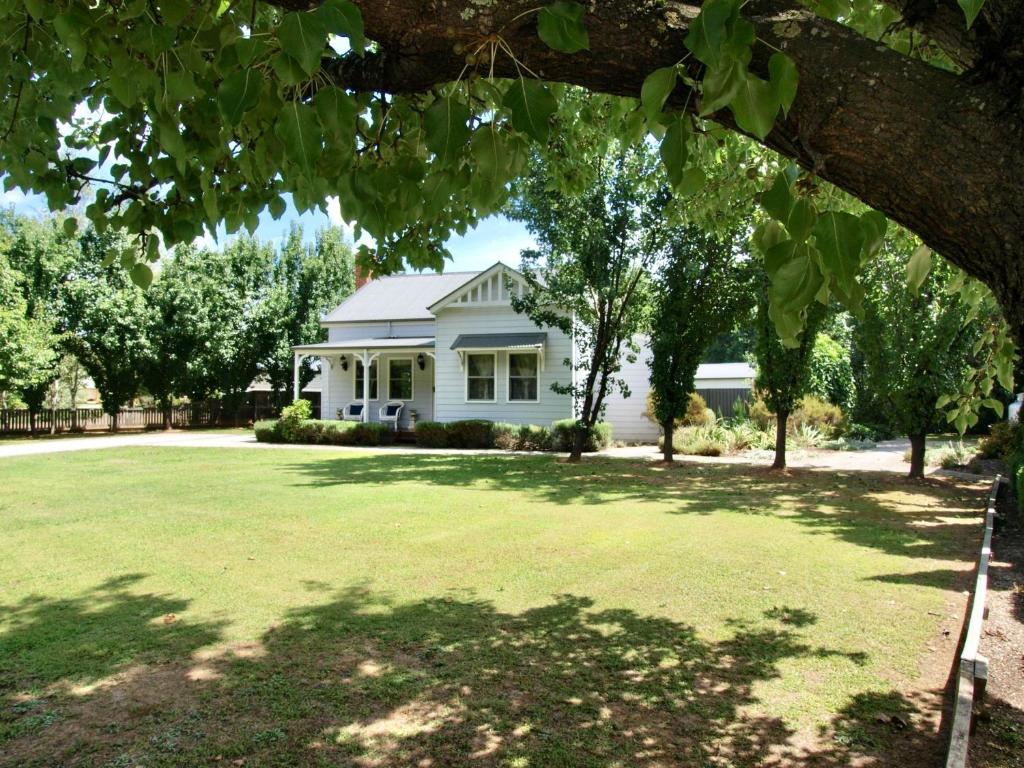 a white house with a large lawn in front of it at Collins Cottage - Luxury Accommodation in Bright