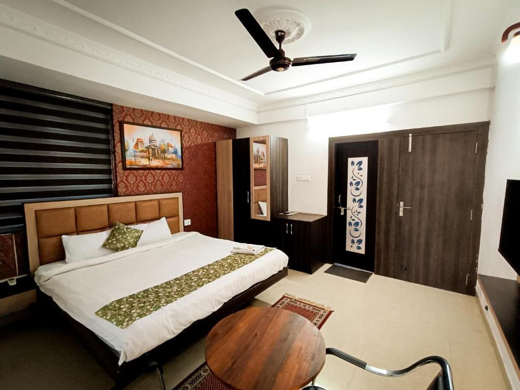 1 dormitorio con cama y mesa de madera en StayVilla Royal Executive Rooms, en Ranchi