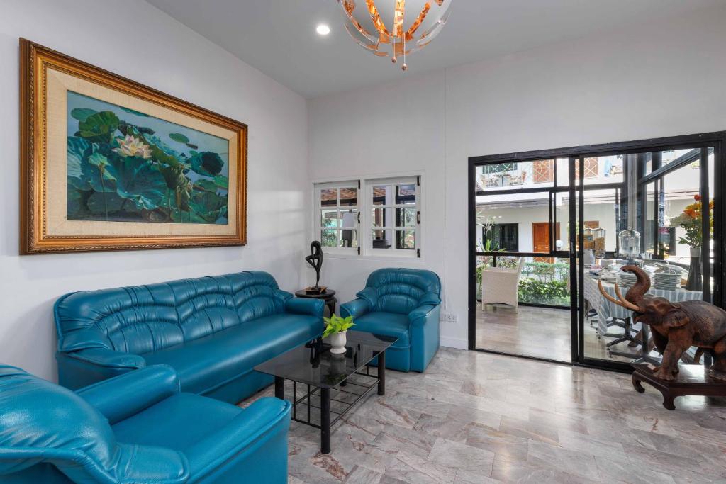 A bright lounge with blue leather seating, artwork, and glass doors to another area.