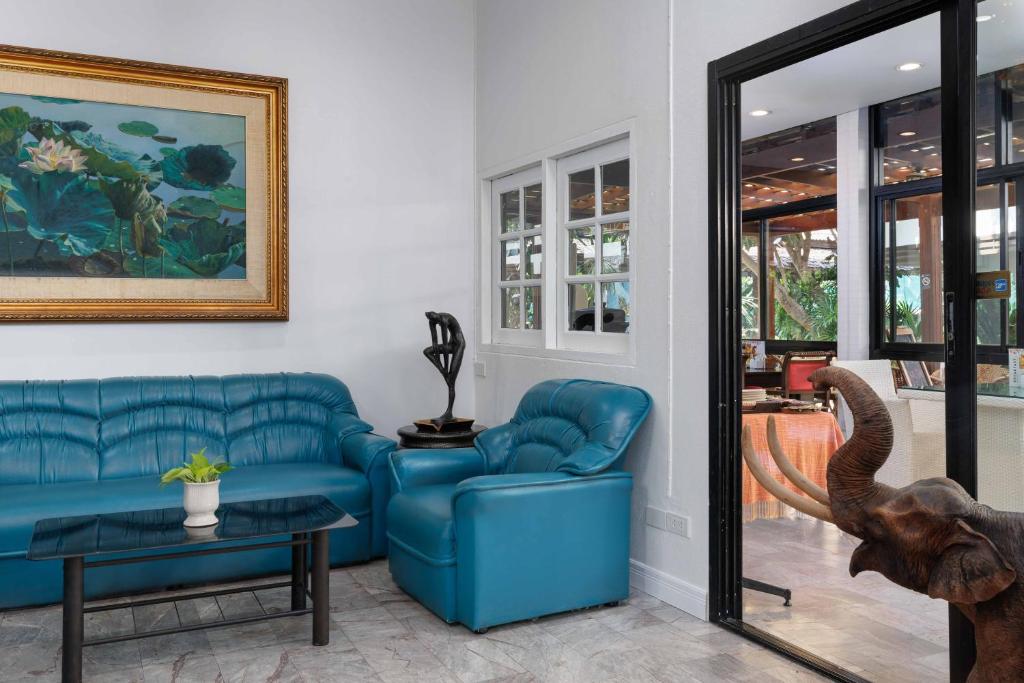 A blue leather sitting area beside glass doors and a large decorative elephant.