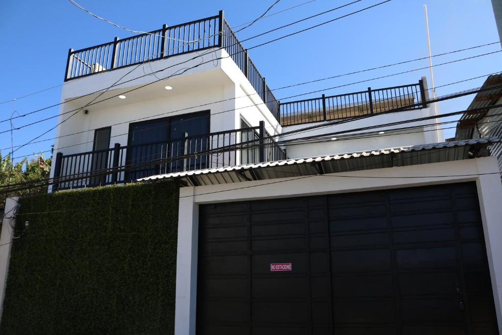 ein weißes Haus mit einer Garage und einem Balkon in der Unterkunft Casa Francisca 