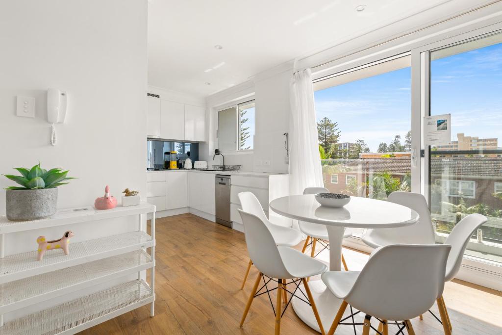 a kitchen and dining room with a table and chairs at Chic apartment footsteps from Manly Beach in Sydney