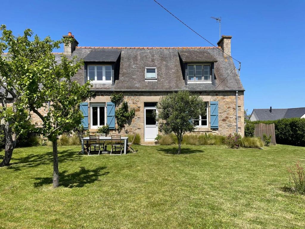 a large stone house with a picnic table in the yard at Charmante maison 3* près de la plage, jardin privé, WiFi, idéale pour découvrir la Côte de Granit Rose - FR-1-542-59 in Trégastel
