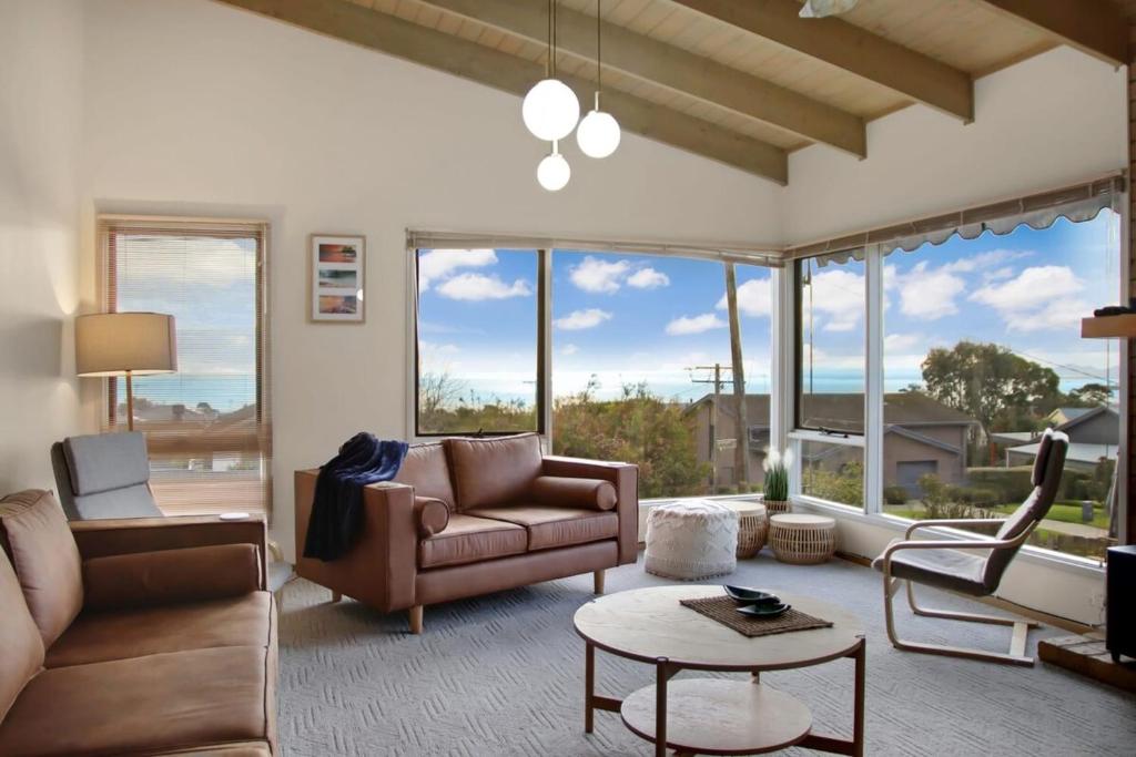 a living room with a couch and chairs and windows at Seven Views I Pool Table n Water Views in Clifton Springs