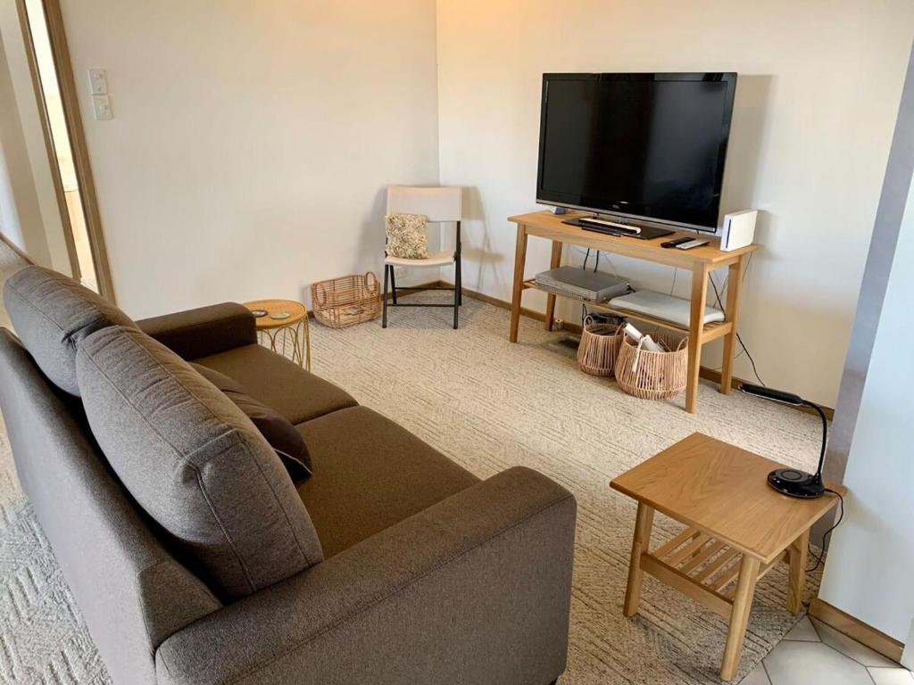 a living room with a couch and a flat screen tv at Seven Views I Pool Table n Water Views in Clifton Springs