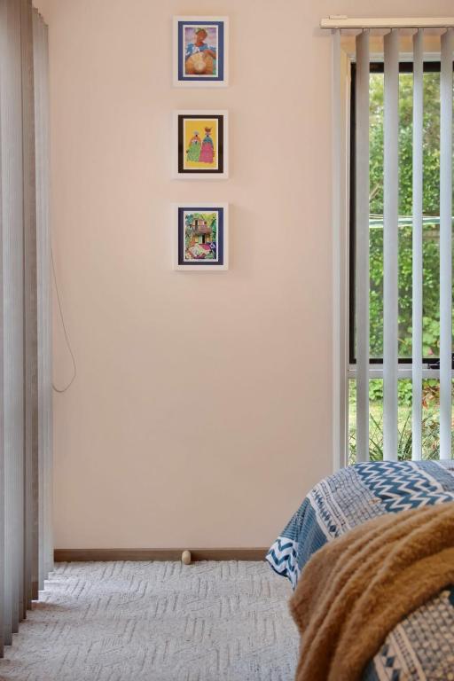 a bedroom with three pictures on the wall and a window at Seven Views I Pool Table n Water Views in Clifton Springs