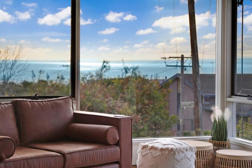 a living room with a couch and a large window at Seven Views I Pool Table n Water Views in Clifton Springs