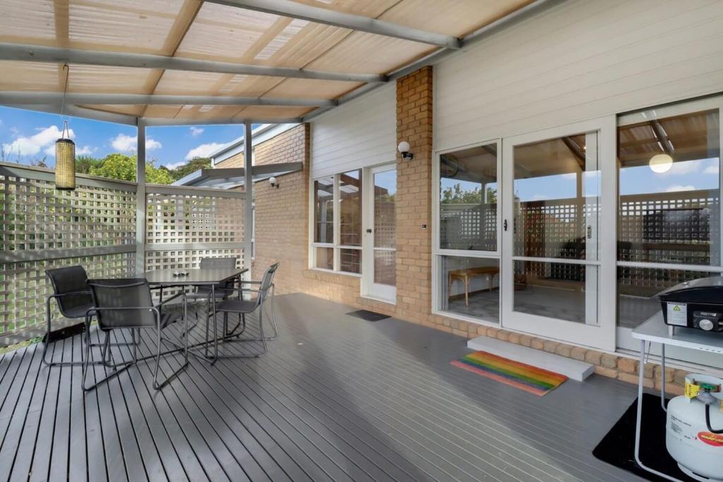 a patio with a table and chairs on a deck at Seven Views I Pool Table n Water Views in Clifton Springs