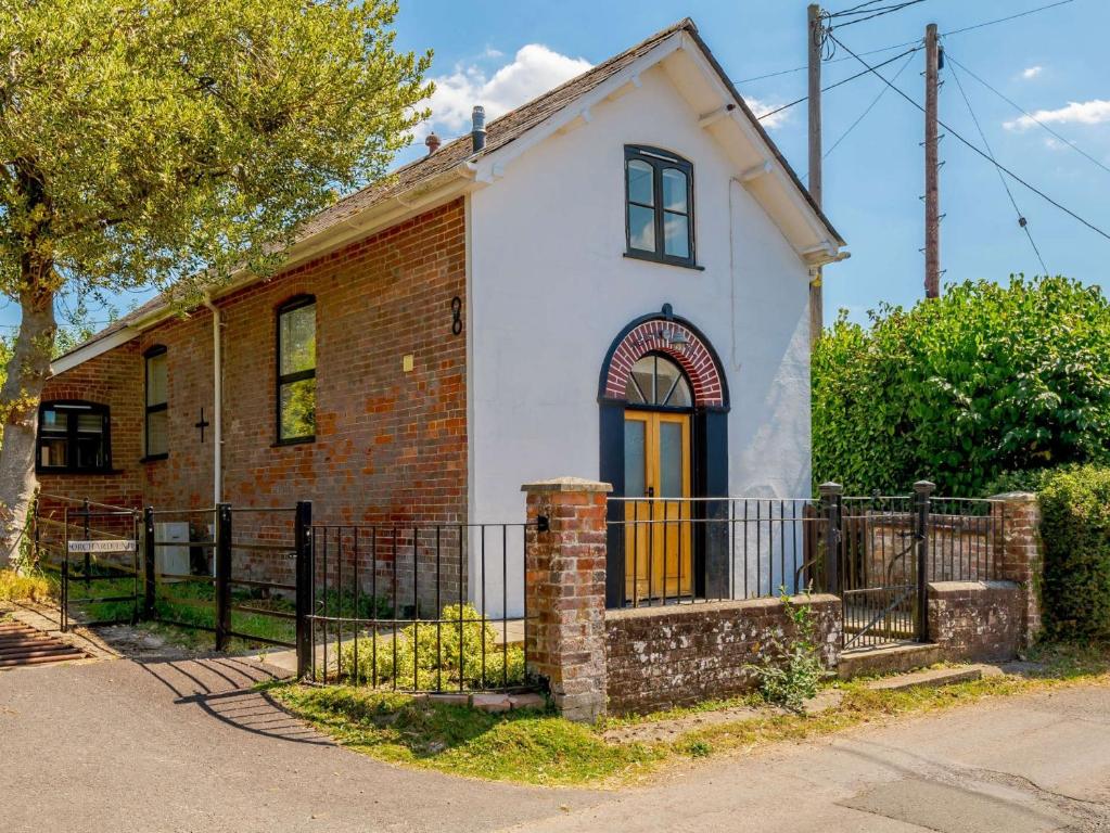 an old brick and white house with a gate at 2 Bed in Fordingbridge 56823 in Woodgreen