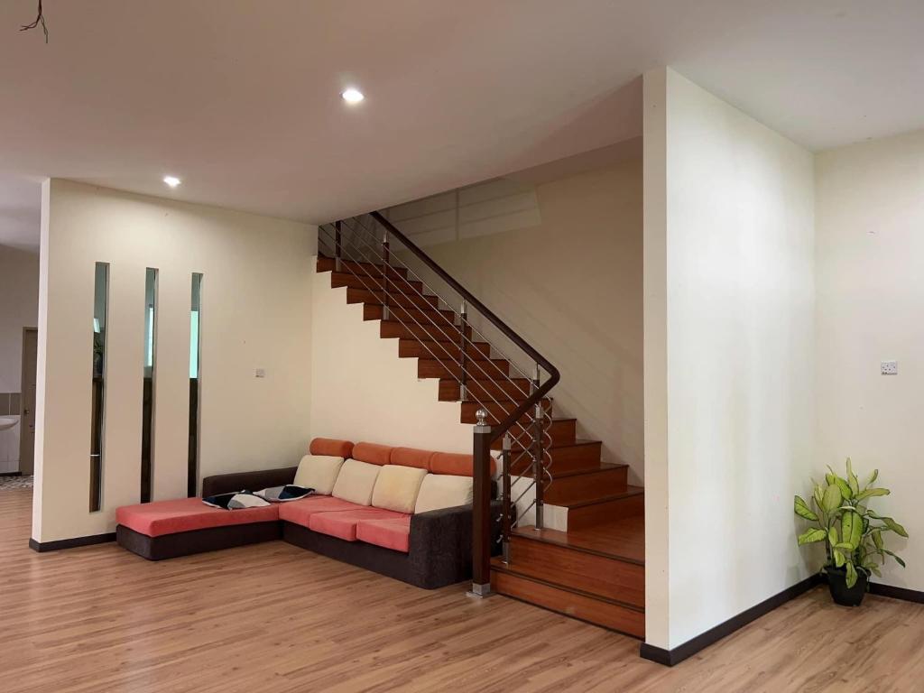 a living room with a couch and a staircase at 1717 Bintulu Homestay 1 in Bintulu