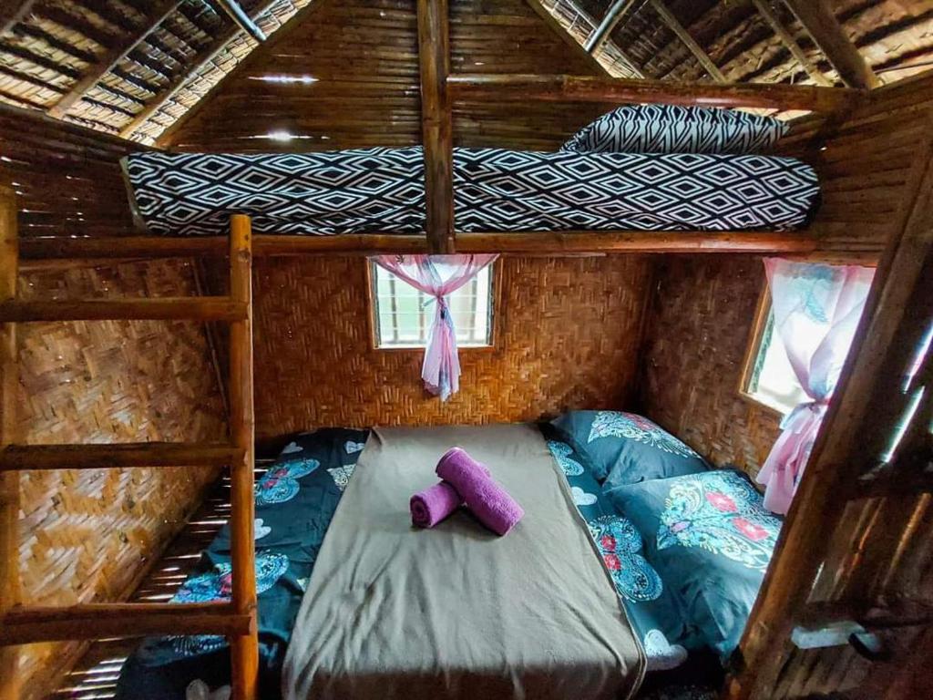 a room with two bunk beds and a purple pillow at Elvira's Homestay in Looc