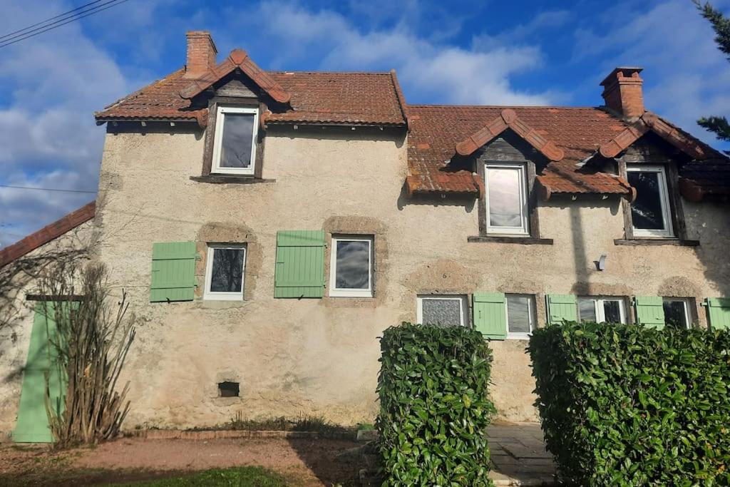 een oud huis met groene luiken erop bij La petite maison de Chavroches - proche du Pal 