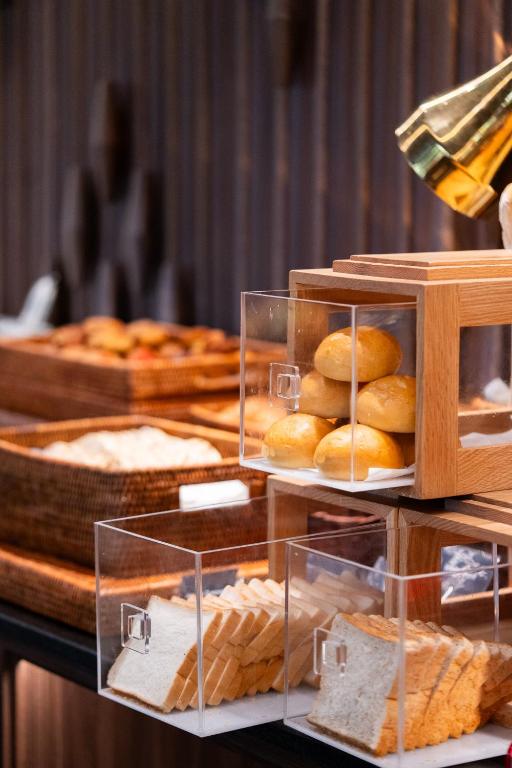 A close-up of bread, rolls and pastries in clear buffet display boxes.