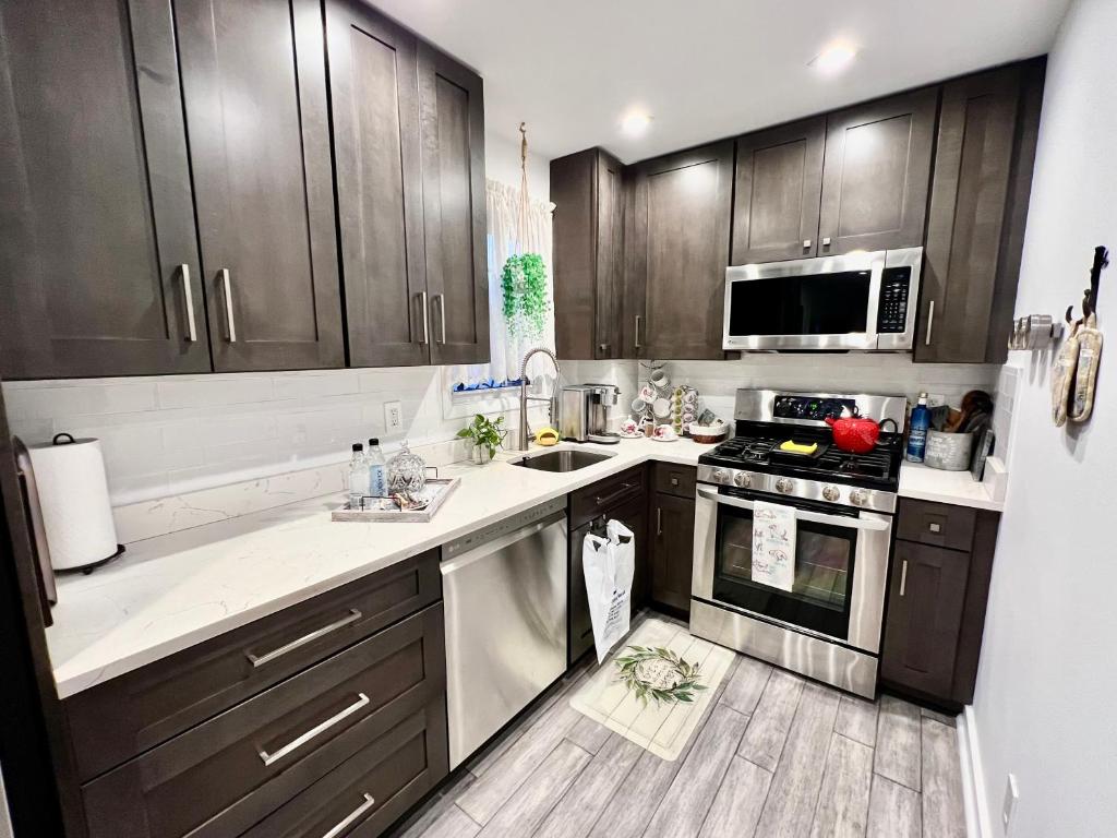 a kitchen with wooden cabinets and a stove top oven at Eleni’s Charming Studio in North Beach