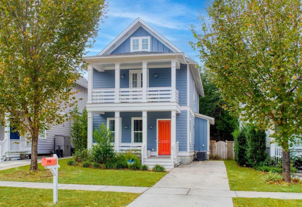 a blue house with a red door and a yard at Shem Creek House- 5 Mins to Downtown & Beach in Charleston