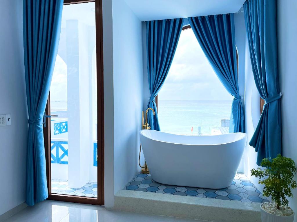 Baño con bañera frente a una ventana en VILLA BIỂN XANH 3 - View Biển Đảo Phú Quý, en Cu Lao Thu