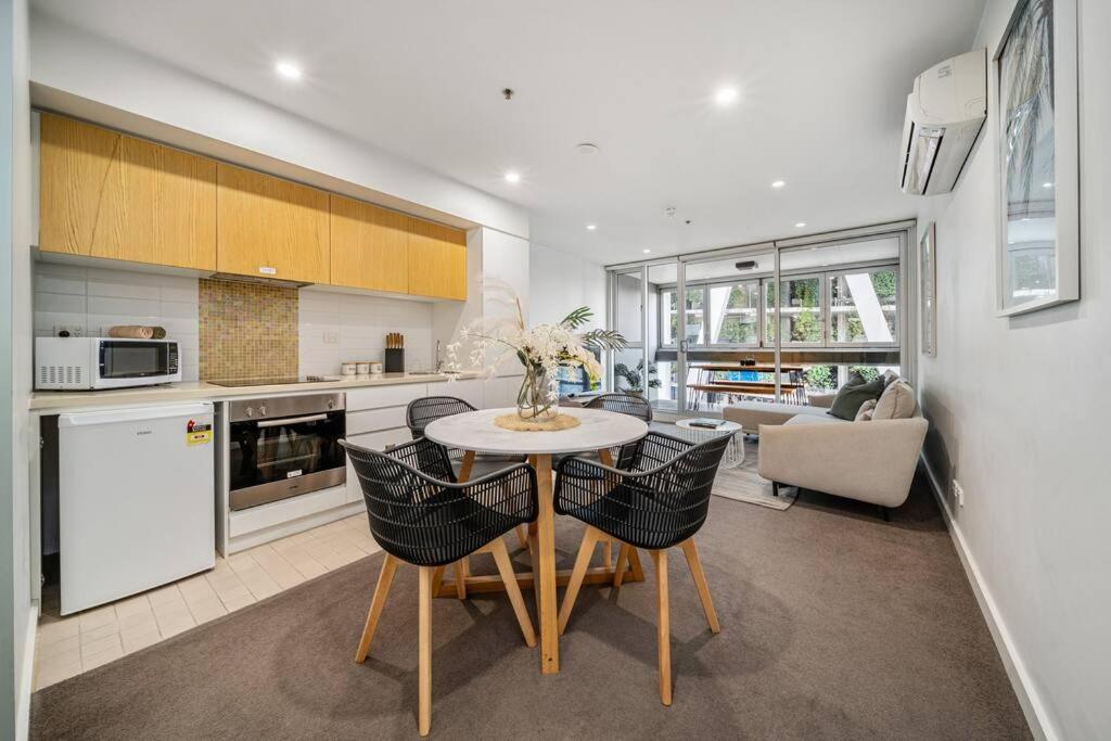 a kitchen and dining room with a table and chairs at Bliss at Balfours - CBD Escape with Pool & Hot Tub in Adelaide
