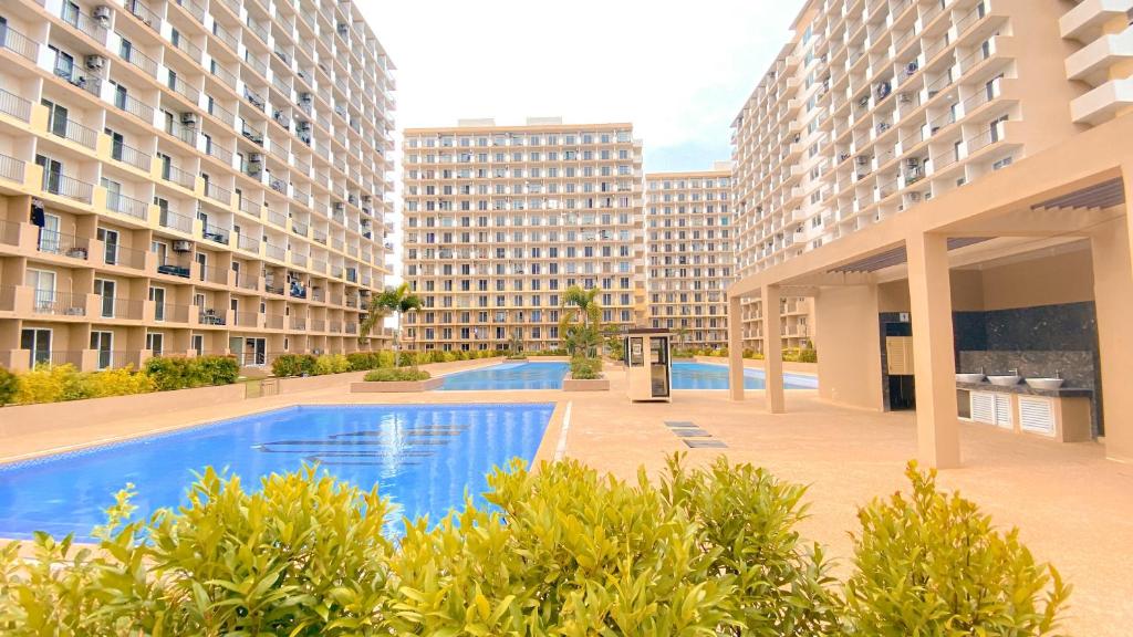 a swimming pool in the middle of two apartment buildings at Sea & City lights View in Lapu Lapu City