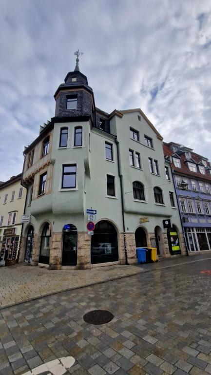 un gran edificio blanco con una torre en una calle en Pension Stadtmitte Jena, en Jena