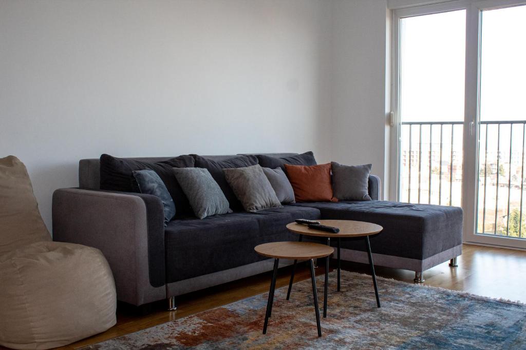 ein Wohnzimmer mit einem blauen Sofa und einem Tisch in der Unterkunft Skyline Apartment 1 in Peja