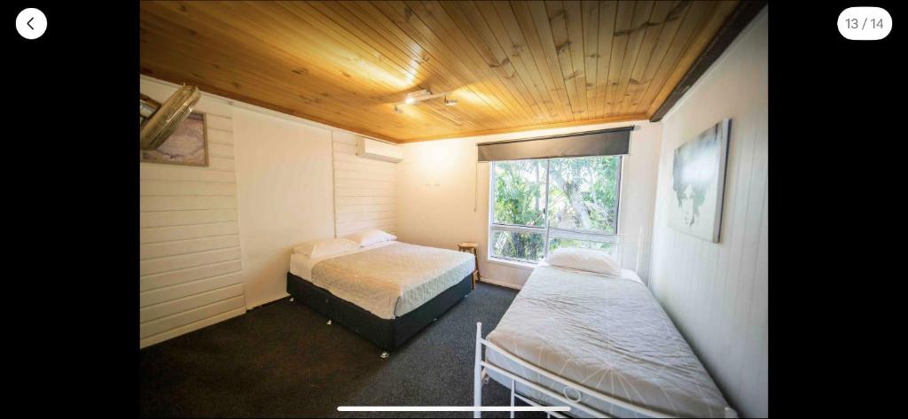 a bedroom with two beds and a window at Grimshaw House in Cairns