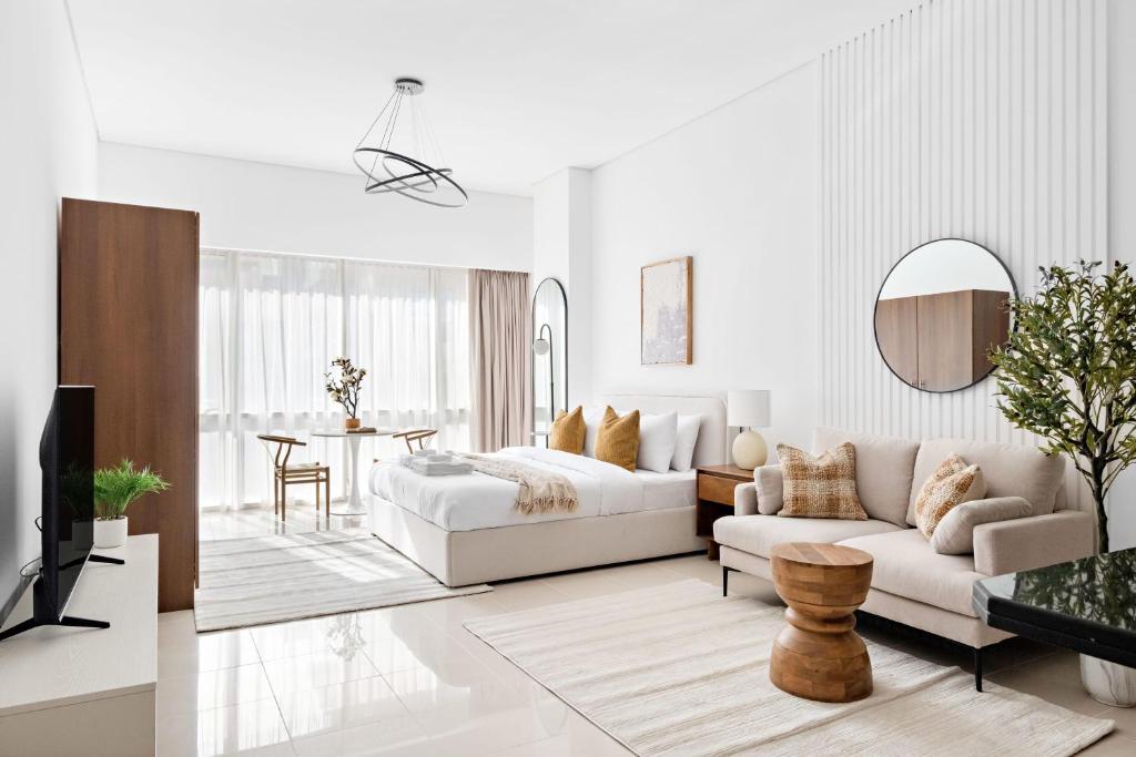 Sala de estar blanca con cama y sofá en Silkhaus Bright Studio Near Silicon Central Mall en Dubái