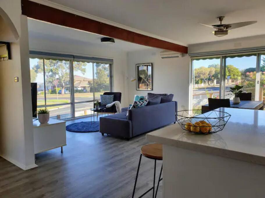 een woonkamer met een bank en een tafel bij Geelong Delight: Embrace Comfort @ Braund Avenue in Norlane