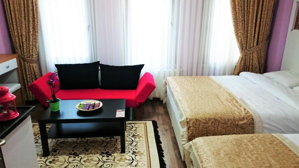 ein Hotelzimmer mit 2 Betten und einem roten Sofa in der Unterkunft Grafen House in Istanbul