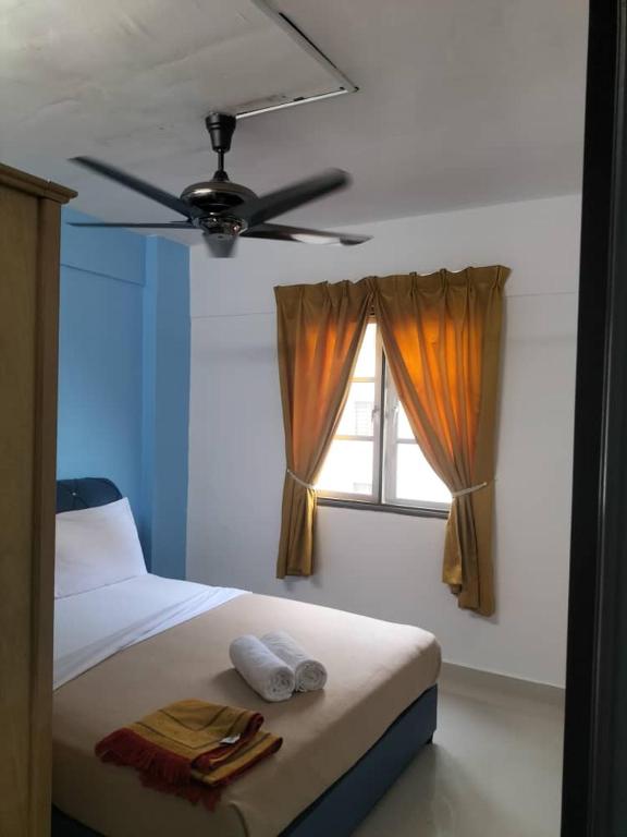 Schlafzimmer mit einem Bett, einem Deckenventilator und einem Fenster in der Unterkunft yaakub homestay seberang jaya in Kampong Belah Dua
