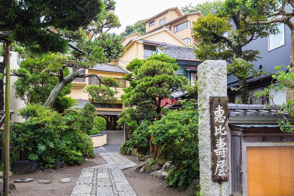 藤沢市にある湘南江の島　御料理旅館　恵比寿屋の木の立つ建物前の通路