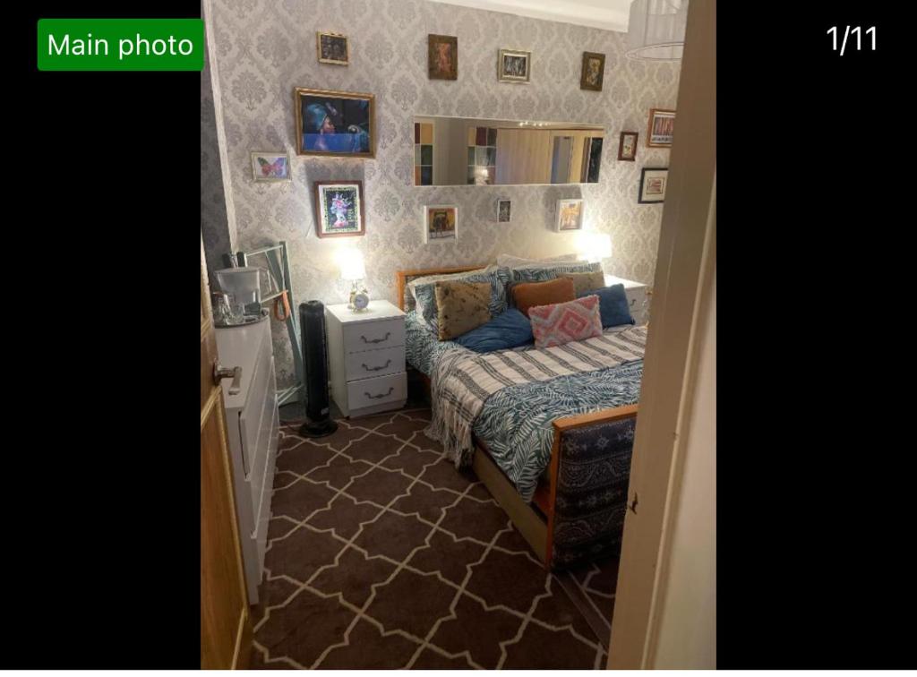 a bedroom with a bed and a wall with pictures at Room in zone 2 in London
