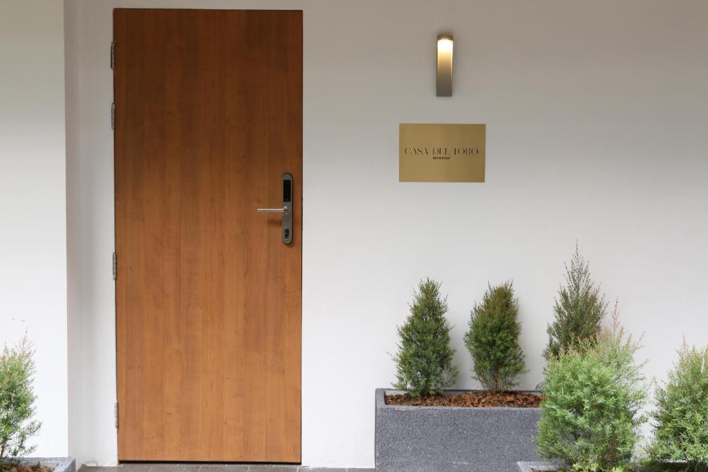 una puerta con un cartel al lado de las plantas en Casa del Toro en Makkasan